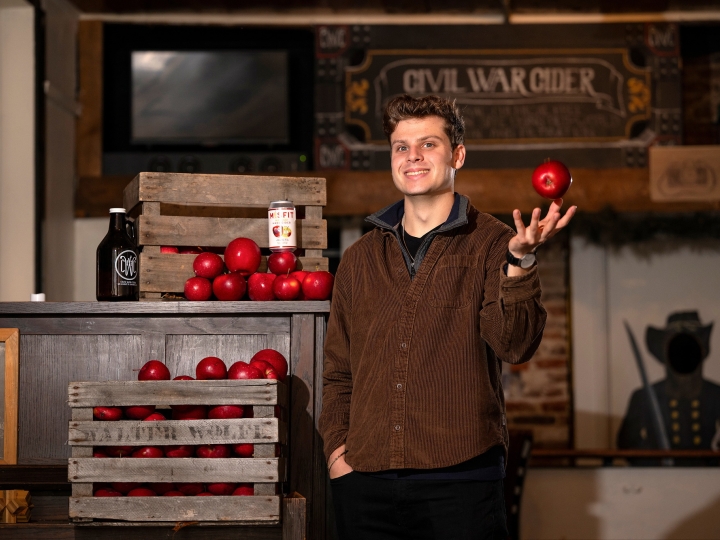 Ben Fink tosses an apple in his right hand at Civil War Cider.
