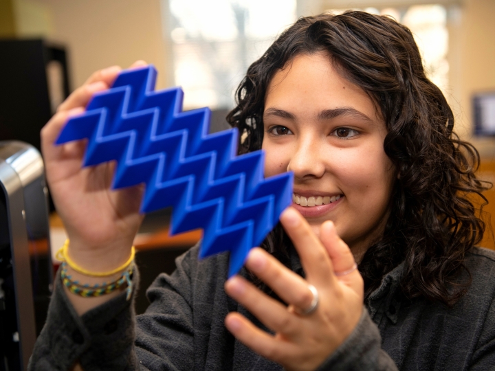 Iona Pitkin &#039;25 looks at a plastic plate with 3D zig-zag design.