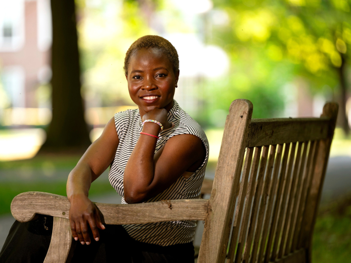 Marie Victoire Alexis sits on a bench on campus and smiles.
