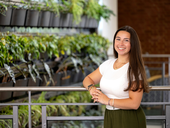 Gianna Sangillo wears a white shirt in front of a green background