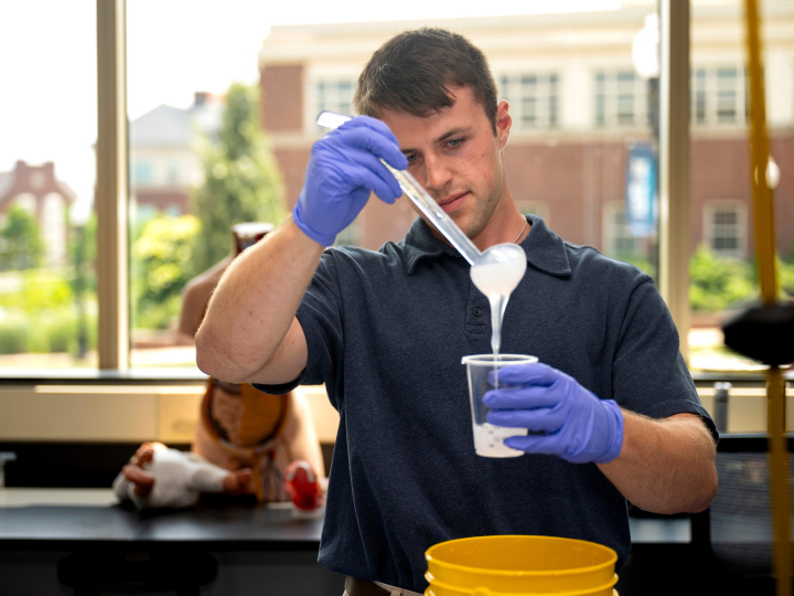 Tanner Tighelaar pours silicon into a mold