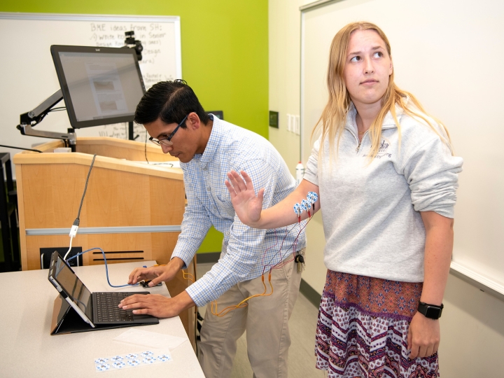 Faculty memeber and student with electrodes on student's arm