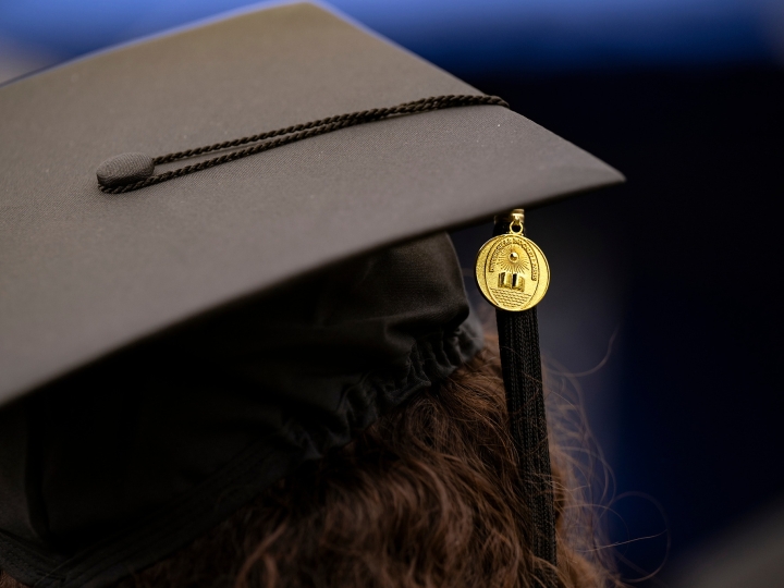 A close-up photo of a graduation cap with a Bucknell medallion and tassel