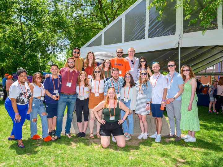 A group of alumni pose in front of the KLARC U Bison during reunion