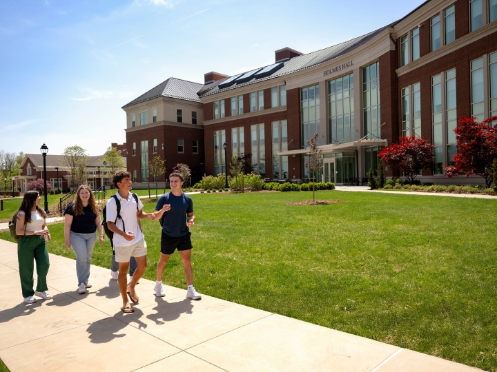 Students walk in front of Holmes Hall