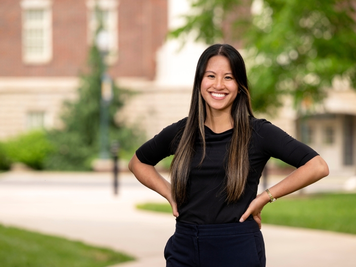 Professor Olivia Boerman stands outside, smiling, with her hands on her hips.