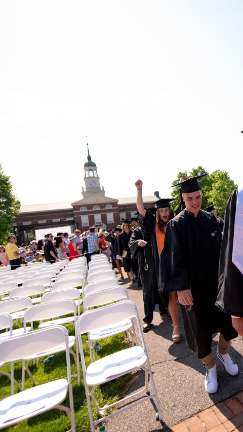 Graduates in cap and gown process into Commencement