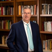 Portrait of President John Bravman in a library