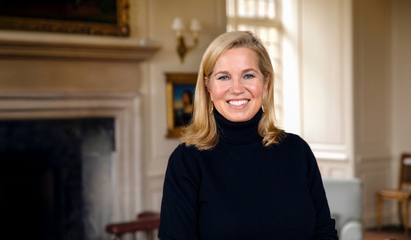 Jessica Livingston smiles in front of a fireplace
