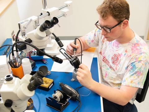 Student solders electronics in the Maker-E