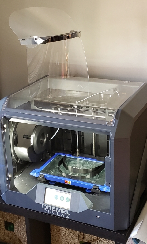 A prototype PPE face shield on top of a 3D printer