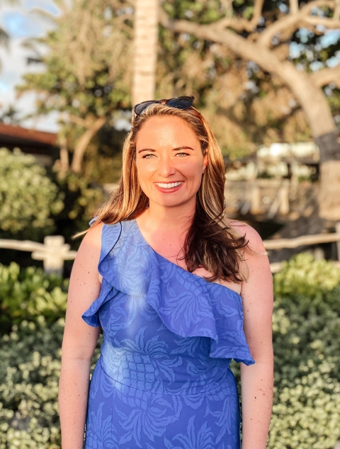 A girl in a blue dress smiles at the camera
