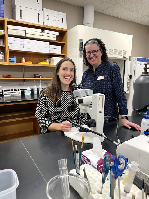 Juliet King '18 with mentor Professor Julie Gates in a biology lab with a microscope.