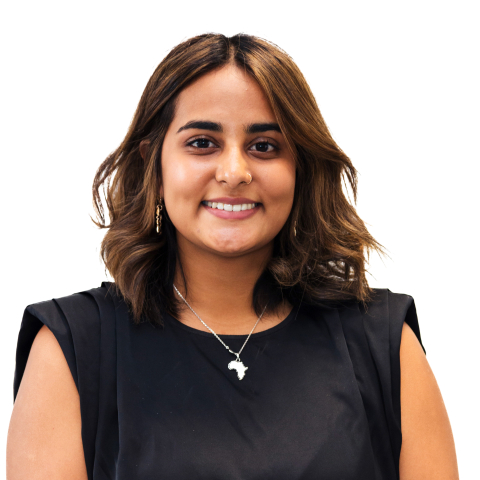 Deepshikha Parmessur smiles while wearing a black top and African pennant necklace against a white backdrop.
