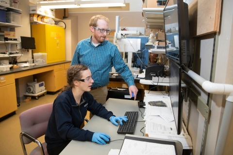 Hurlock and Collins analyze data on computer screens in the lab.