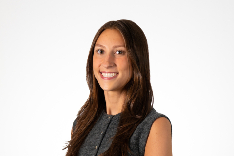 Alyssa Zimmer '26 wears a sleeveless, buttoned gray top and smiles against a white backdrop.