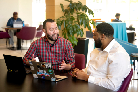 A career accelerator coach and a senior bucknell student have a conversation sitting at a table.