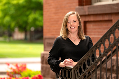 Lauren Baillie smiles on the steps of the Carnegie building at Bucknell.