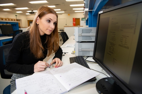 Emily Bayuk reads a circuit diagram on a computer screen