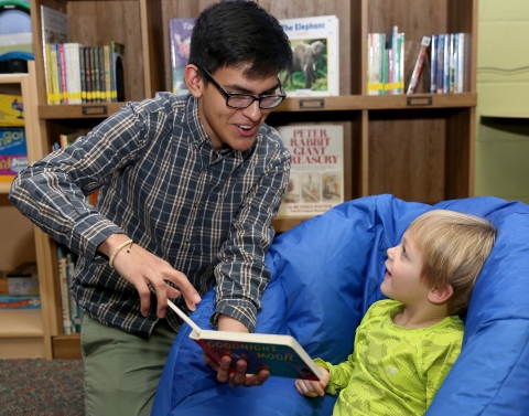 Management 101 student reads to a child