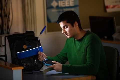 Shehryar looks at the solar backpack and light.