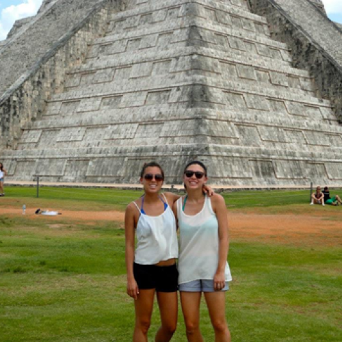 Two women in front of pyramid.